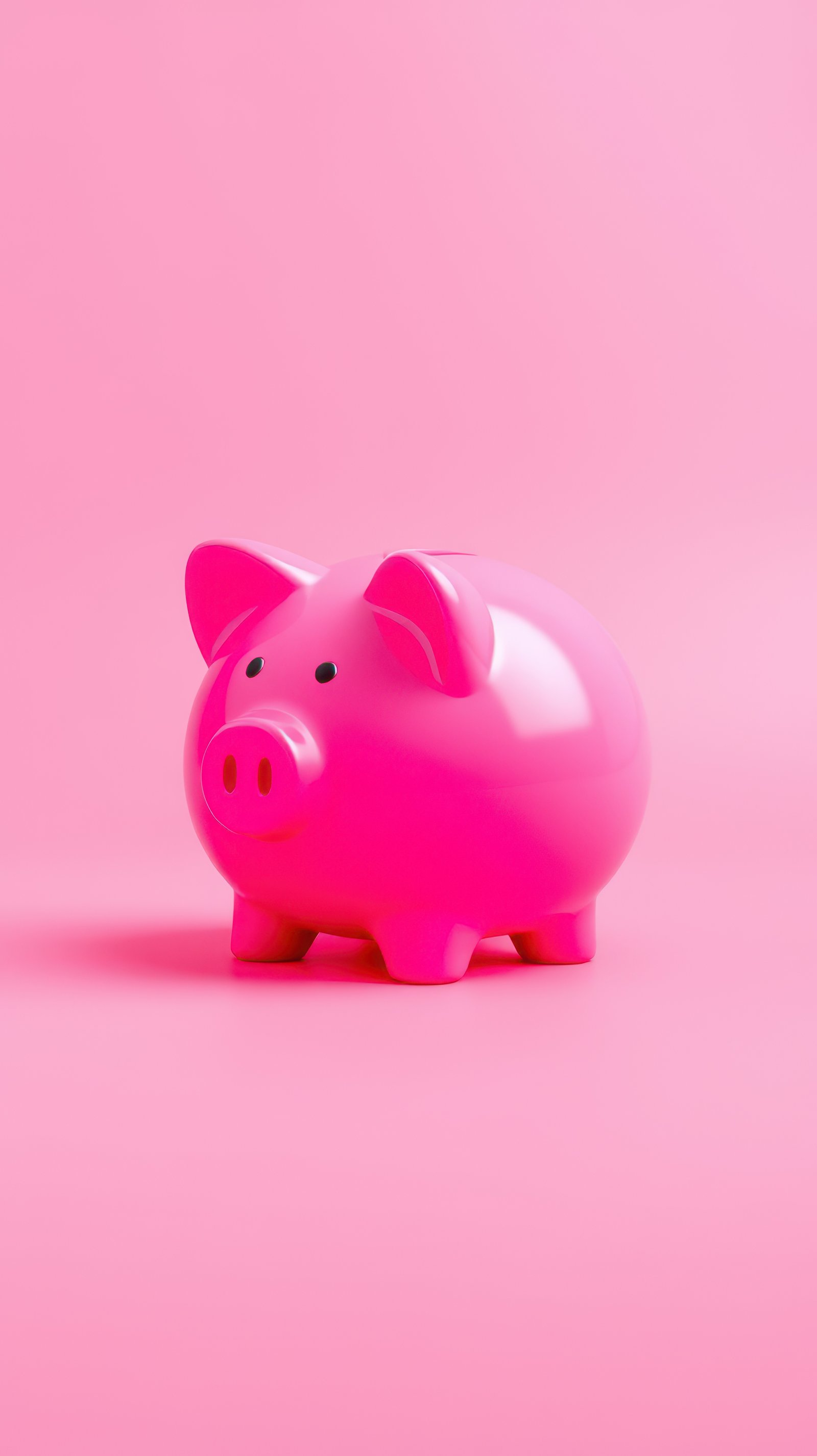 Bright pink piggy bank symbolizes saving and financial goals in a playful, minimalistic setting